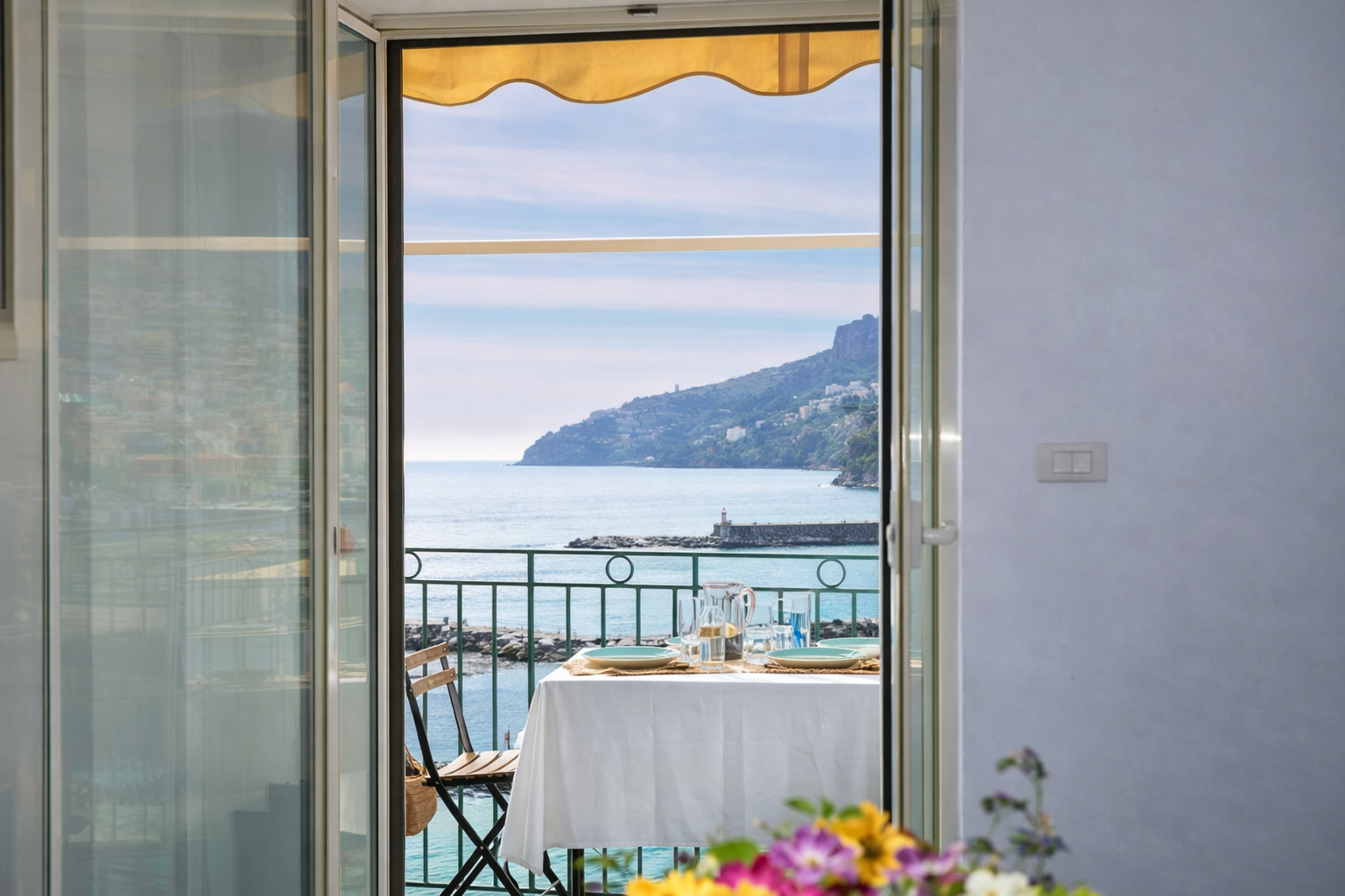Terrazza con tavolo apparecchiato per due affacciata sul mare cristallino di Amalfi - appartamento con balcone vista mare Costiera Amalfitana